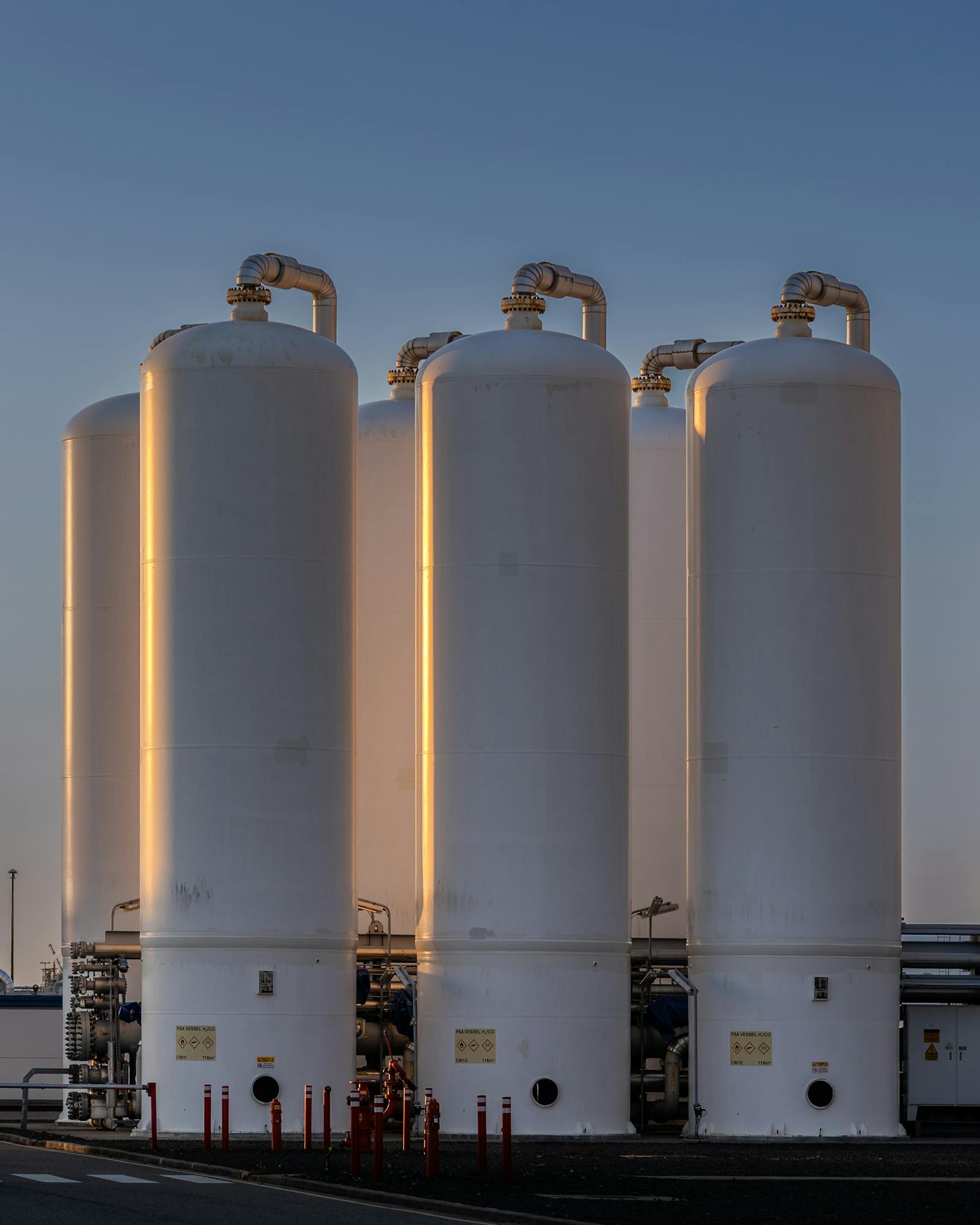 Green hydrogen pressure-swing-adsorption storage vessels at a clean fuel facility at sunset